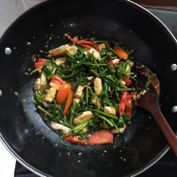 Aduk rata dan masak hingga kangkung layu, kemudian tes rasa lalu matikan api.