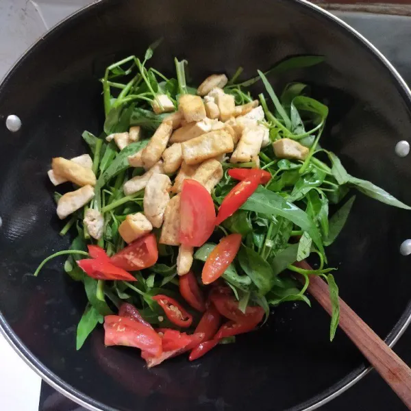 Masukkan juga tomat iris, cabai merah dan tahu putih yang sudah di goreng tadi.