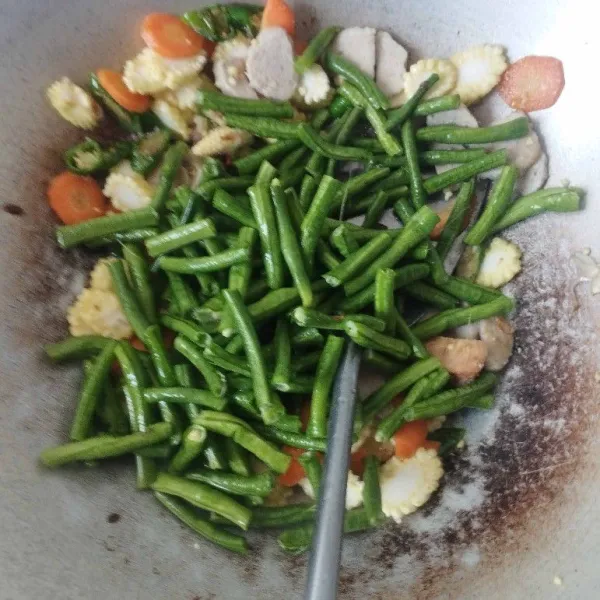 Masukkan potongan kacang panjang, aduk rata. Lalu, tuang air.