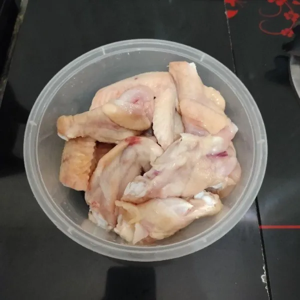 Potong sayap ayam menjadi 2 bagian. Lalu cuci bersih dan masukkan ke dalam mangkok. Sisihkan.