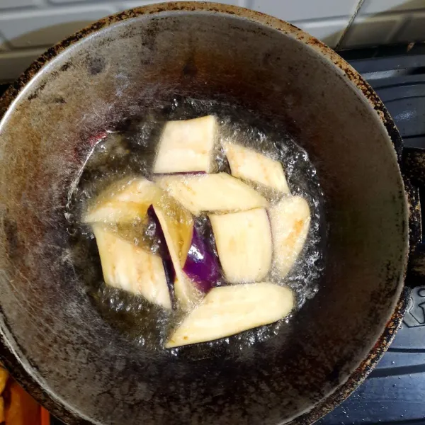 Setelah minyak panas, masukan terong ke dalam wajan lalu masak hingga matang dengan menggunakan api sedang.