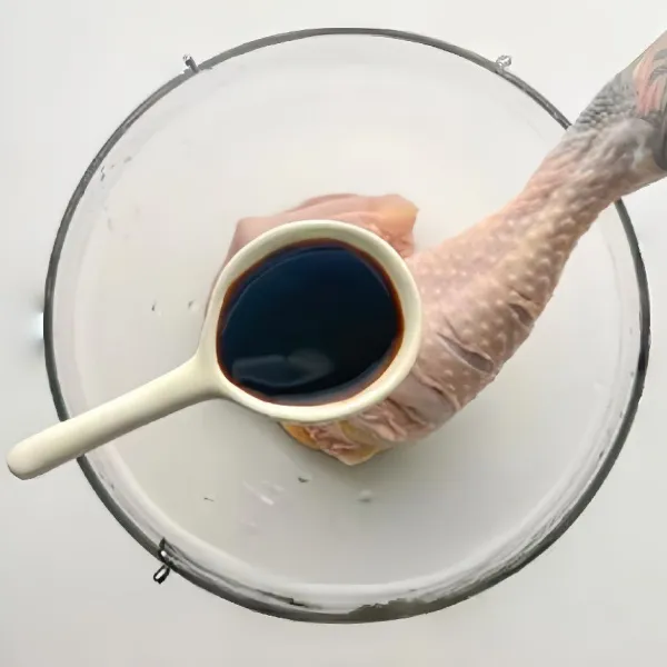 Terlebih dulu iris permukaan paha ayam beberapa kali untuk membantu bumbu meresap. Masukkan 2 sdm kecap asin ke dalam paha ayam