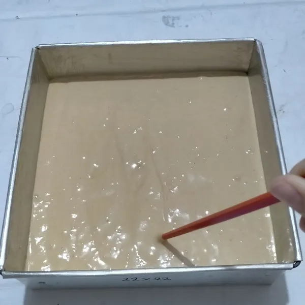 Tuang ke loyang ukuran 22x22 yang sudah diberi alas baking paper dan olesan margarin di sisi loyangnya.Buat gerakan memutar dengan sumpit/tusuk sate untuk mengeluarkan udara yang terperangkap di dalam adonan.Hentakan loyang
