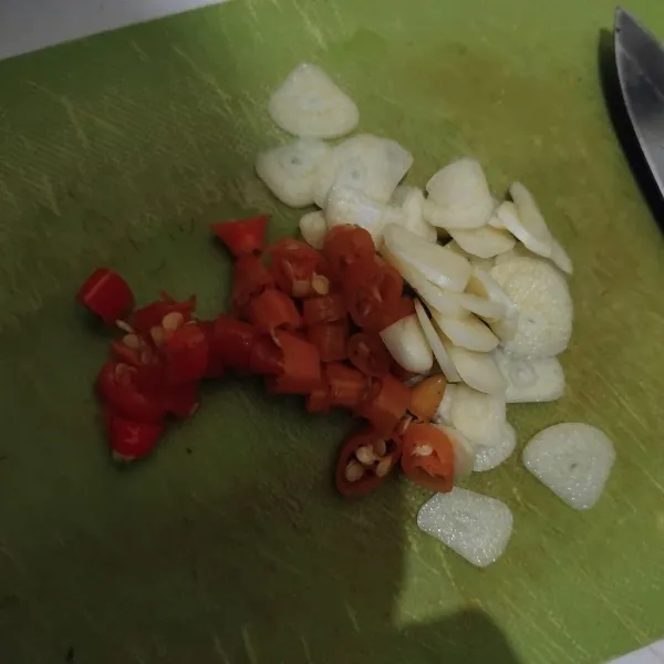 Iris tipis bawang putih dan cabe rawit.