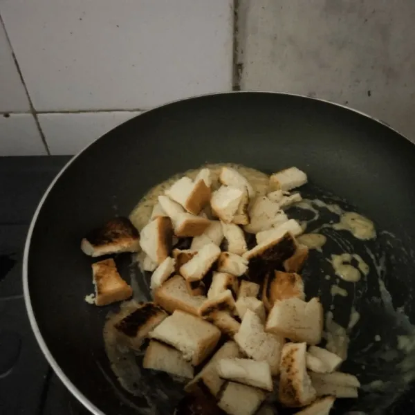 Masukkan potongan roti yang telah disangrai, aduk rata lalu sajikan dengan taburan keju lagi.