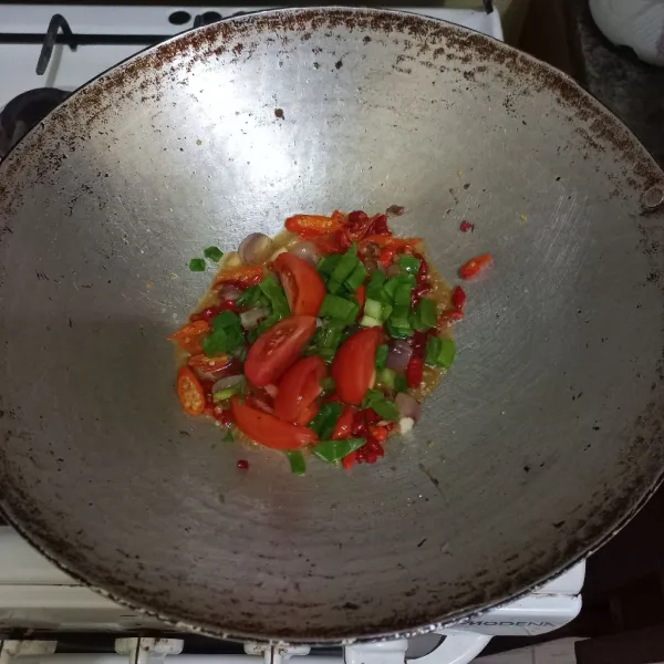 Masukan irisan bawang daun dan tomat aduk rata