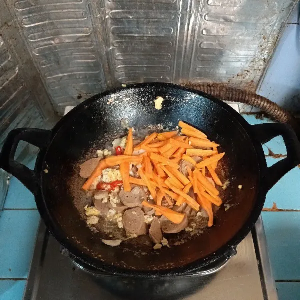 Tambahkan irisan wortel, aduk rata. Masak kembali hingga setengah matang.
