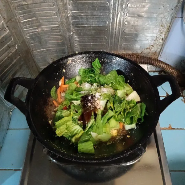 Masukkan daun sawi, saus tiram, garam, gula, kaldu bubuk dan lada. Aduk rata.