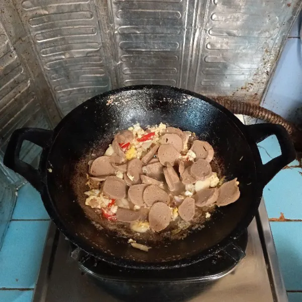 Masukkan irisan bakso, lalu tuang air, masak hingga mendidih.