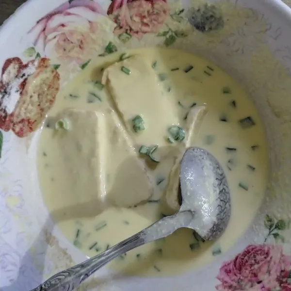 Tambahkan air es sedikit demi sedikit sambil aduk-aduk hingga adonan berubah menjadi kental seperti adonan tempura.
Celupkan potongan-potongan tempe ke dalam adonan tepung hingga semua permukaan tempe terbalut rata.