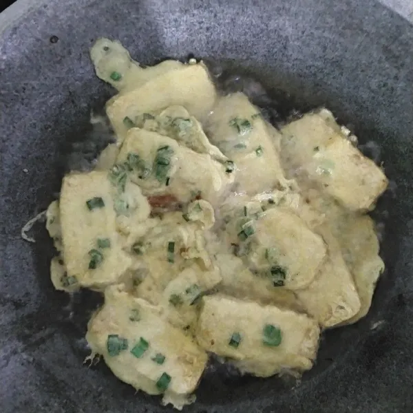 Panaskan minyak dalam wajan dengan api sedang-tinggi. Goreng tempe yang sudah dibalut tepung dalam minyak panas hingga keemasan dan renyah, sekitar 2-3 menit setiap sisi.