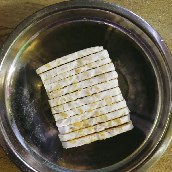 Potong tempe, lalu campur tepung terigu, tepung beras, tepung tapioka (jika digunakan), ketumbar bubuk, merica bubuk, dan garam dalam sebuah mangkuk besar.