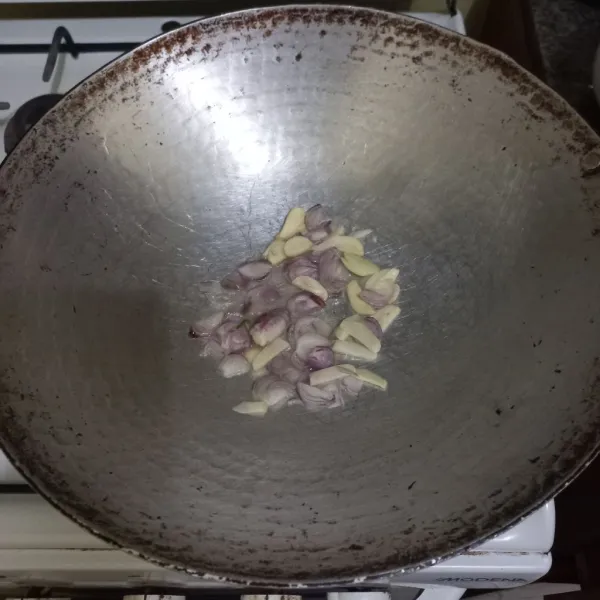 Tumis irisan bawang merah dan bawang putih hingga harum