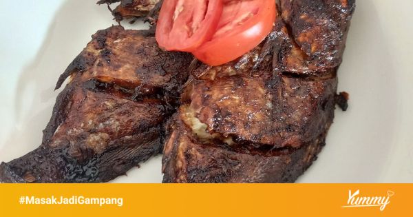 Proses memasak kuah pliek u ikan mujair di dalam panci dengan api kecil