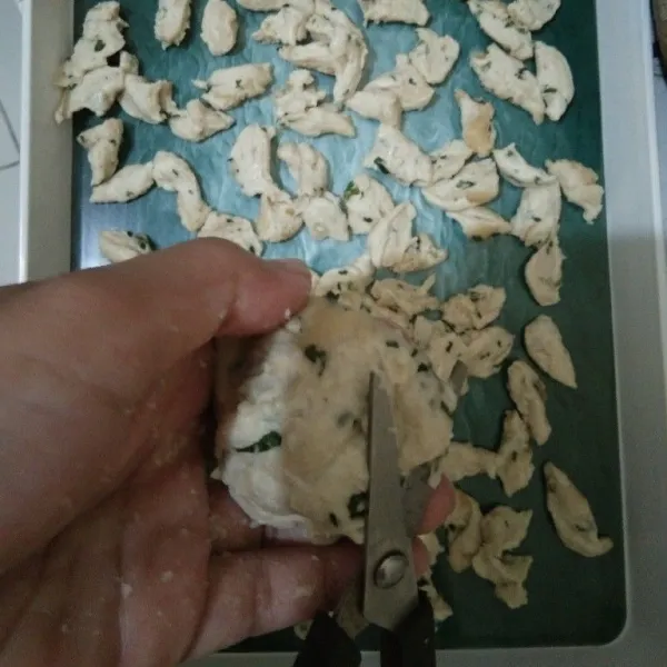 Siapkan baki lalu kepalkan adonan dan potong-potong adonan menggunakan gunting hingga habis