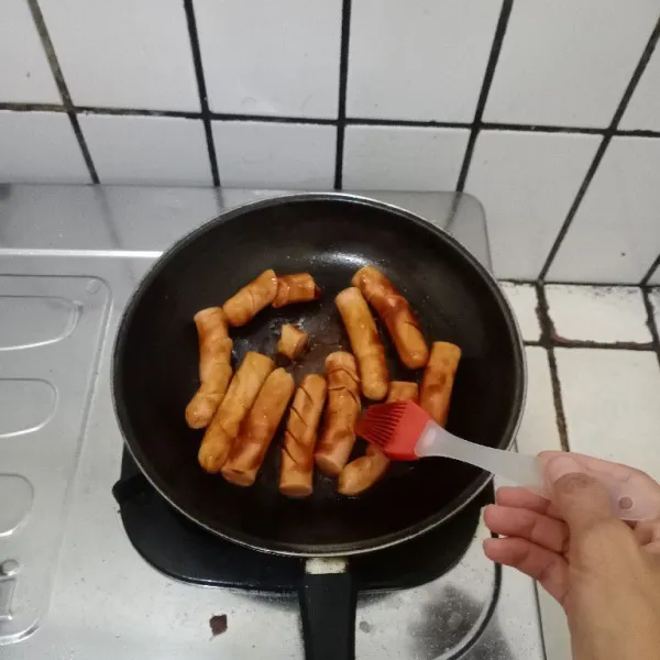 Panaskan margarin lalu masukan sosis, lalu oles lagi dengan bumbu, bolak balik sampai rata dan matang.