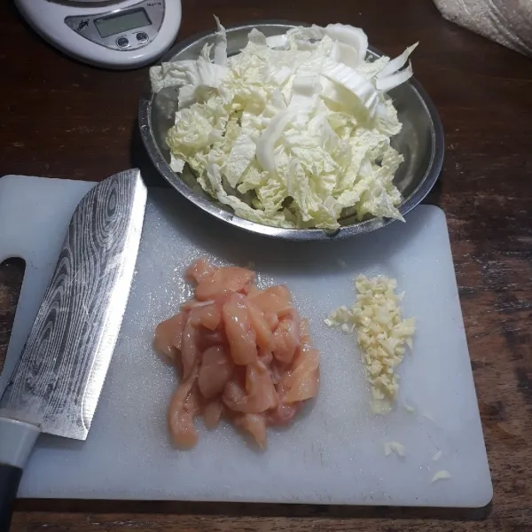 Cincang bawang putih, potong kecil dan tipis ayam, potong sawi putih.