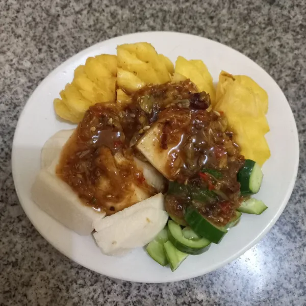 Siram potongan buah dengan bumbu rujak di atasnya