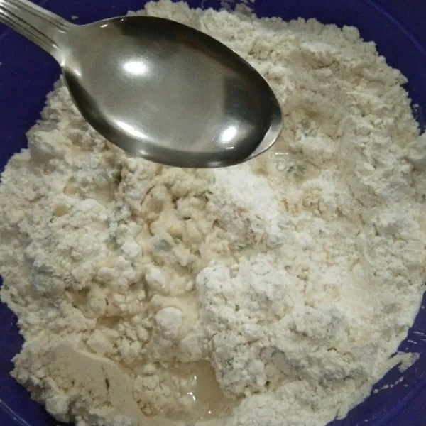 Masukkan tepung terigu perlahan sambil diaduk dan tambahkan 5 sdm air bening