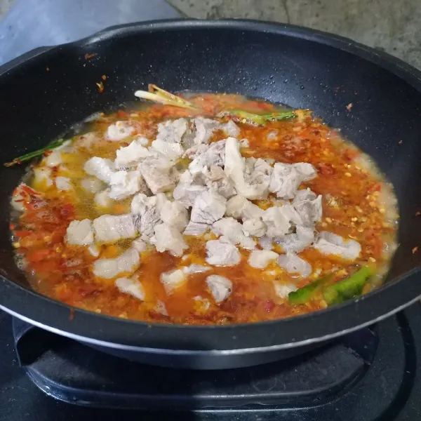 Tambahkan air. Masukkan tetelan sapi yang sudah direbus dan dipotong-potong.