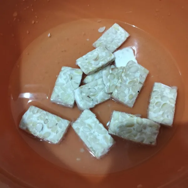 Iris tipis tempe jadi 12. Rendam dalam larutan air garam dan penyedap. Lalu goreng sampai matang. Sisihkan.