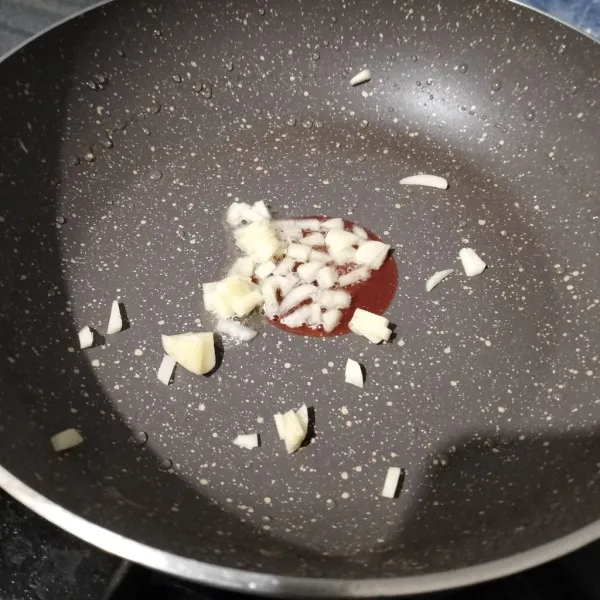 Membuat tumisan daging: Tumis bawang putih sampai layu dan harum.