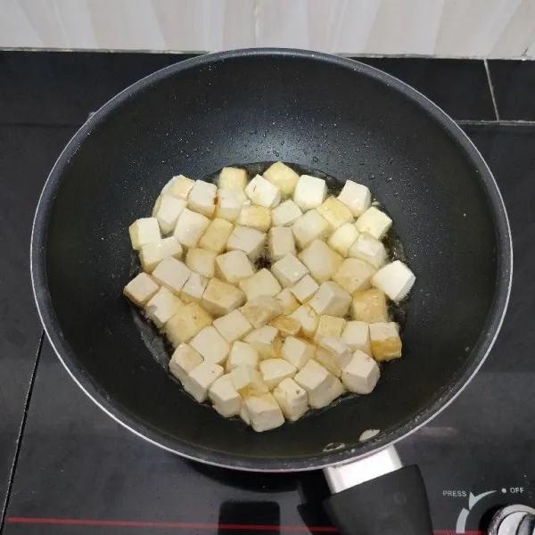 Potong dadu tahu, lalu goreng hingga berkulit tipis, tiriskan.