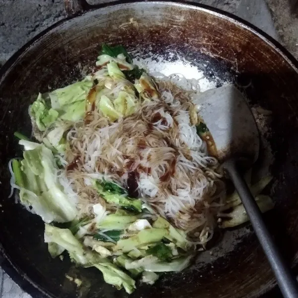 Tambahkan bihun, kecap manis dan saus tiram. Aduk rata.