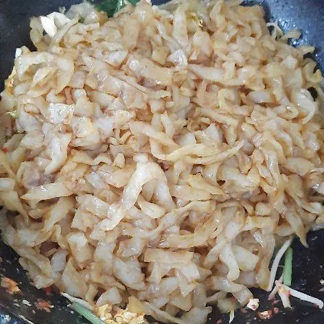 Masukkan kwetiaw yang sudah dimarinasi dengan kecap manis, kecap asin, minyak wijen serta saus sambal. Aduk rata.