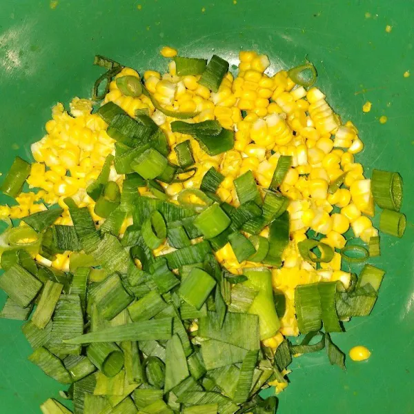 Serut 1 buah jagung dan potong-potong daun bawang.