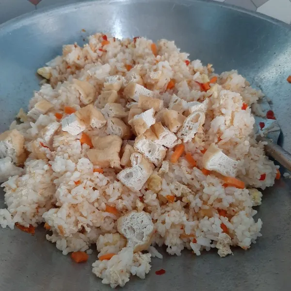 Masukkan irisan tahu goreng dan daun bawang. Aduk rata