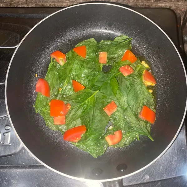 Masukkan bayam dan tomat, masak sampai layu.
