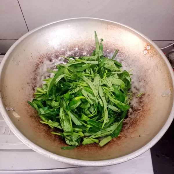 Masukan daun kangkung. Tambahkan sedikit air