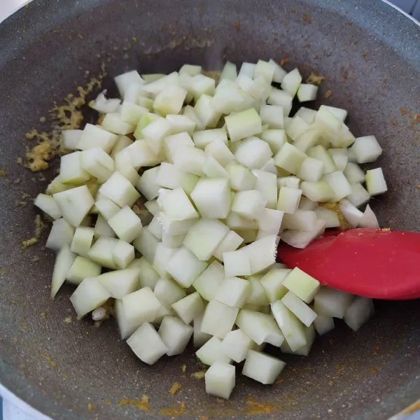 Masukkan pepaya muda yang sudah dipotong dadu, aduk rata dengan bumbu.