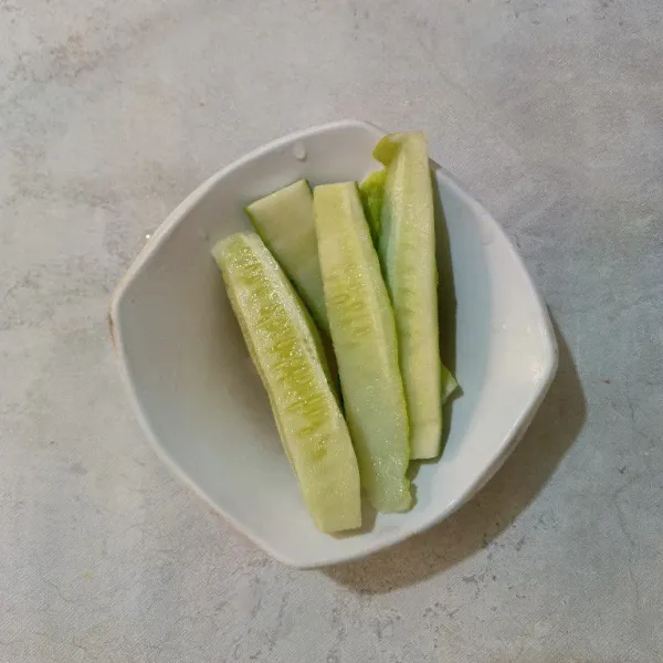 Cuci bersih mentimun, lalu pisahkan biji dan daging mentimun.