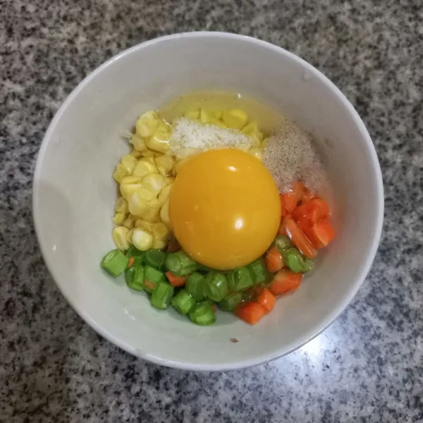 Pecahkan telur ayam di atasnya, beri garam kaldu jamur, dan merica bubuk kocok lepas.