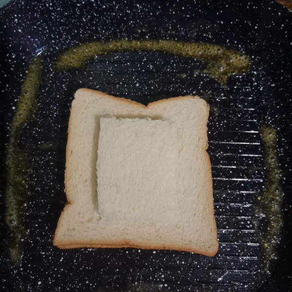 Tutup lubang menggunakan potongan roti tawar. Masak beberapa menit atau hingga telur bagian bawah set.