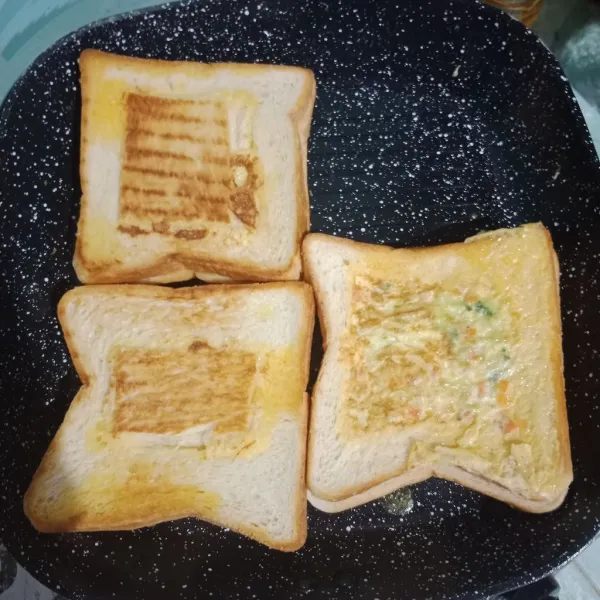 Balik roti, panggang hingga kedua kecoklatan. 6 roti tawar jadi 3 pasang Sandwich