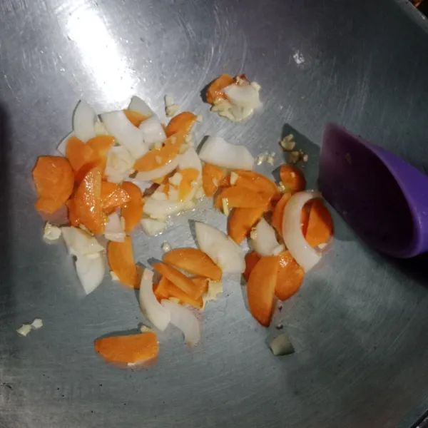 Masukkan wortel lalu bawang bombay. Tumis hingga layu