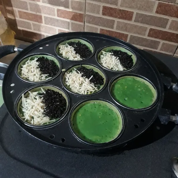 Olesi dengan margarin dan beri toping keju dan meises.