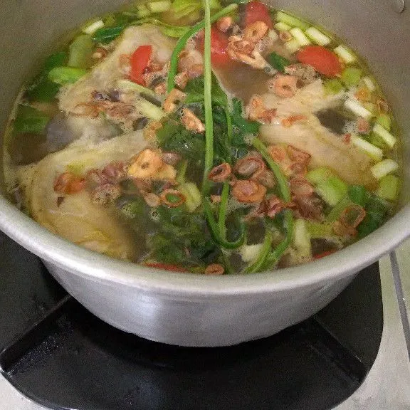 Masak sampai kuah mendidih. Tambahkan daun seledri, tomat iris dan taburi bawang merah goreng. Angkat dan hidangkan.