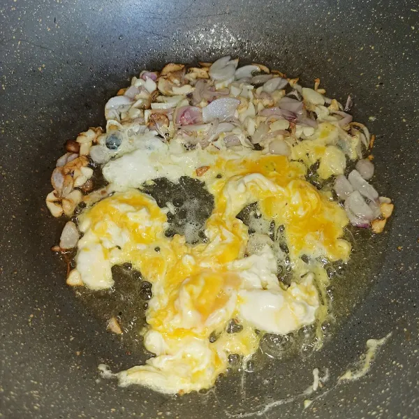 Sisihkan bawang di tepi wajan, lalu ceplok telur dan buat orak arik.