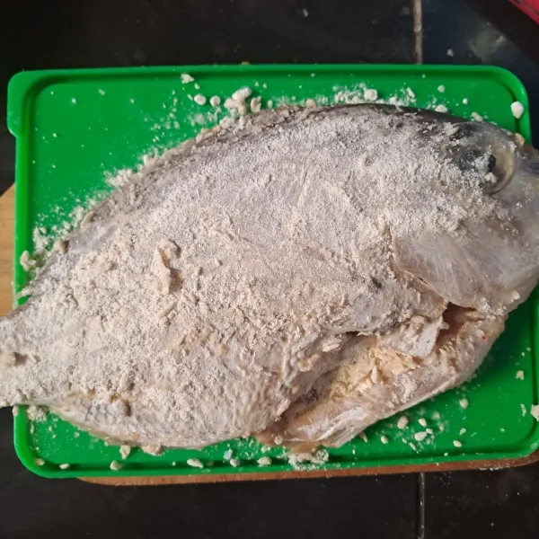 Bersihkan ikan, beri perasan jeruk nipis dan garam. Baluri tepung terigu.