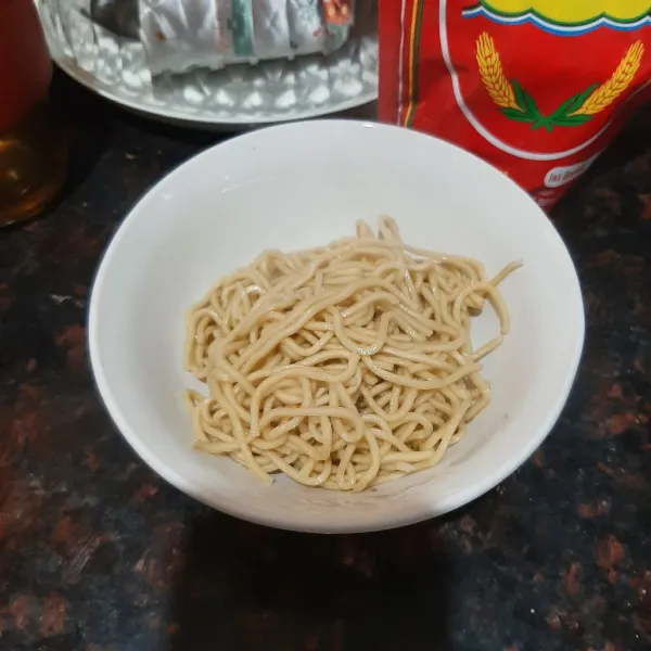 Masukan mie yang sudah di rebus ke dalam mangkuk saji yang sudah di beri minyak ayam dan bumbu lain, aduk rata. Kemudian tambah toping dan kuah, siap disajikan.