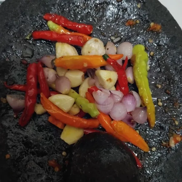 Haluskan bawang merah, bawang putih, cabe merah keriting, dan cabe rawit.