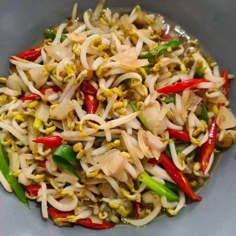 Tambahkan tauge ke dalam wajan, aduk rata. Masukkan saus tiram, kecap manis, gula, garam, dan merica. Aduk hingga semua bahan tercampur rata dan tauge sedikit layu.