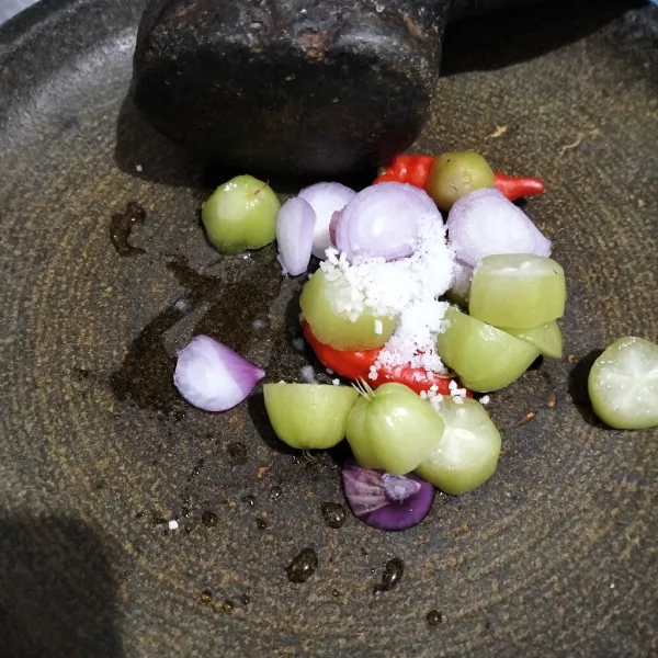 Ulek bahan sambal dengan garam dan penyedap.