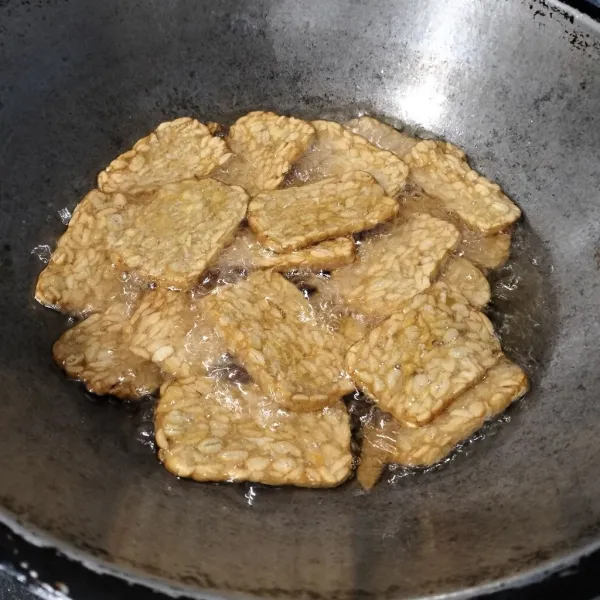 Rendam tempe dalam air garam dan penyedap. Lalu goreng sampai matang
