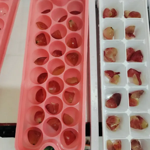 Potong - potong buah anggur lalu susun dalam cetakan puding