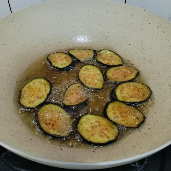 Iris tipis terong lalu goreng hingga matang.